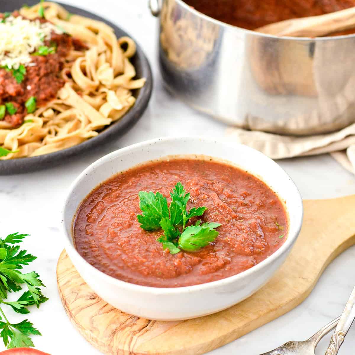 Tomato & Zucchini Pasta Sauce in a bowl, on a plate of noodles and in a pot