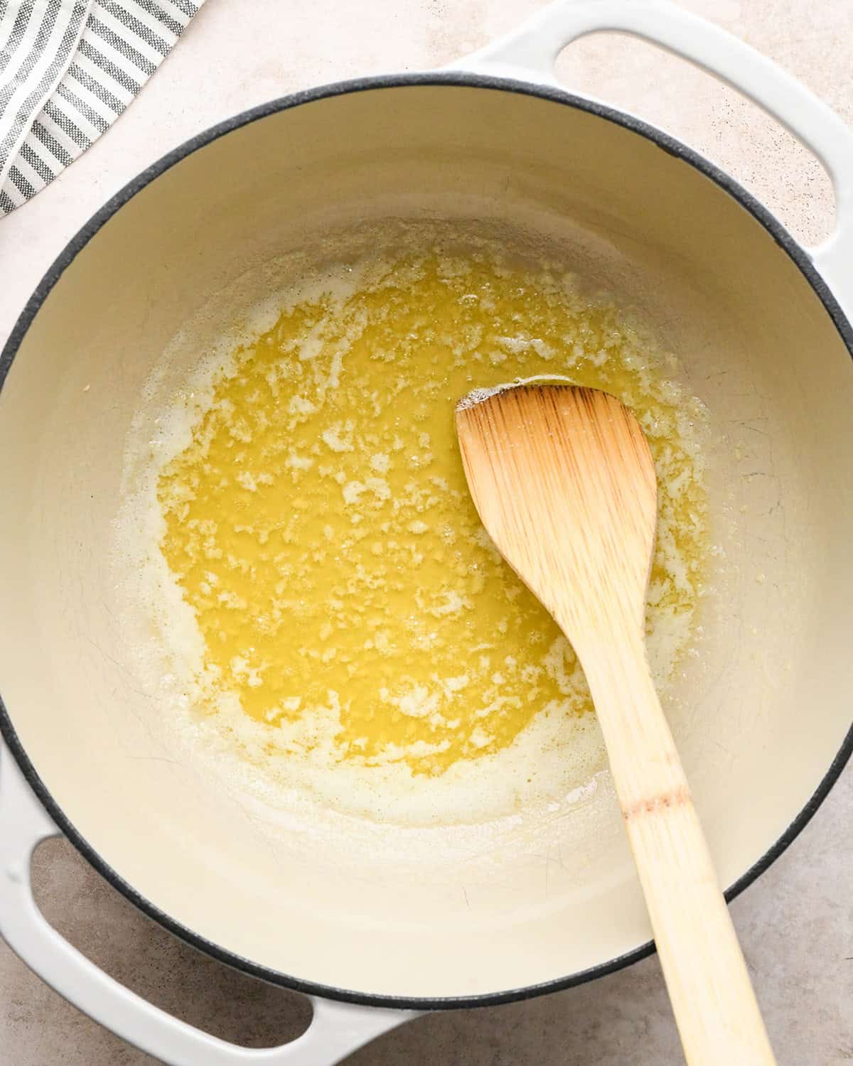 how to make Cacio e Pepe Pasta sauce - butter and garlic after cooking in a pot with a wooden spatula