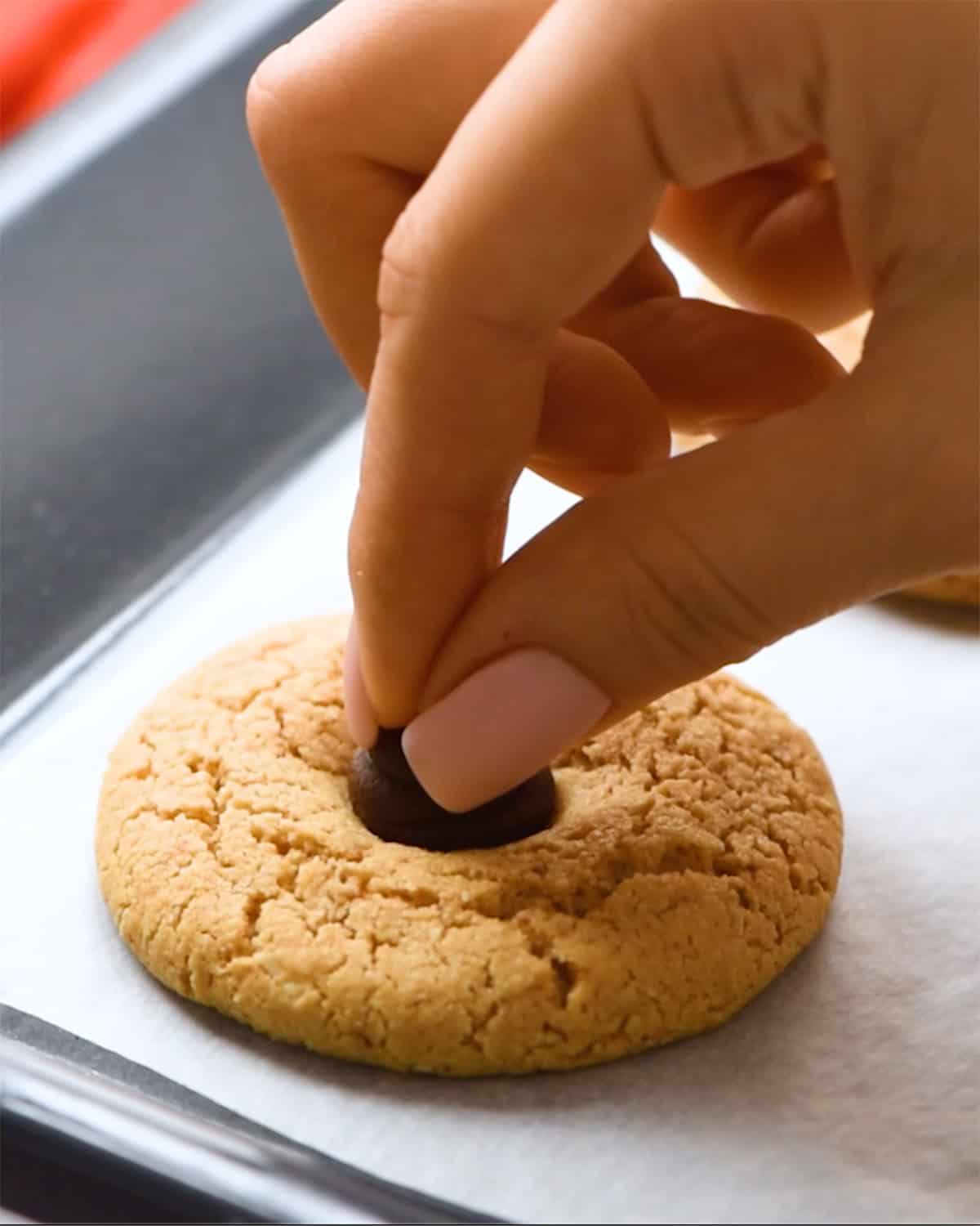 how to make almond butter blossoms - pressing a kiss into a cookie