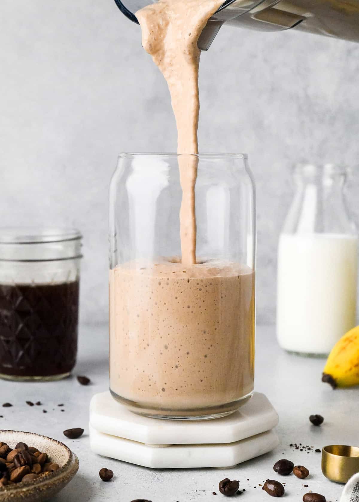Coffee Smoothie being poured into a glass from the blending container