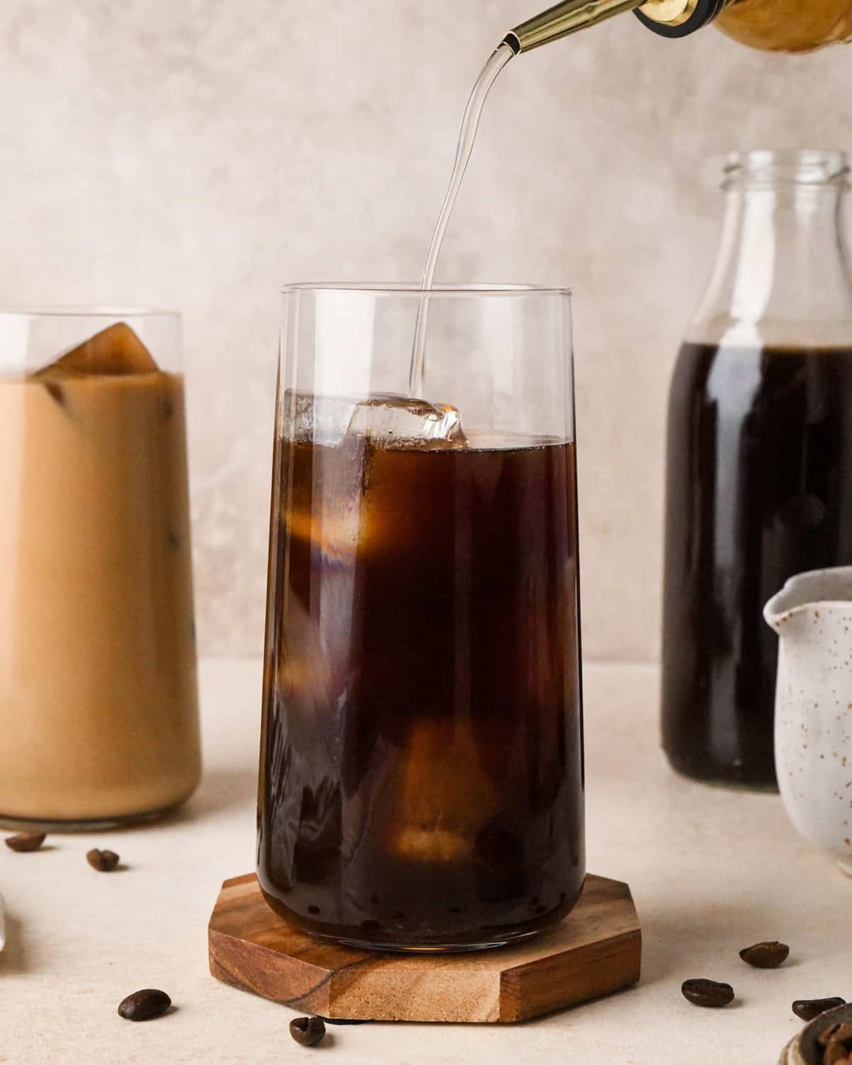simple syrup being poured into a glass of Cold Brew Coffee
