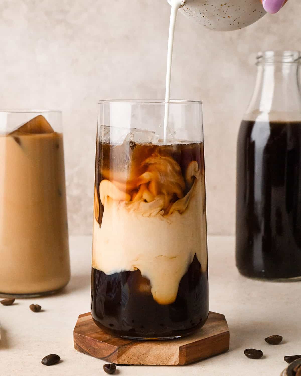 cream being poured into a glass of Cold Brew Coffee