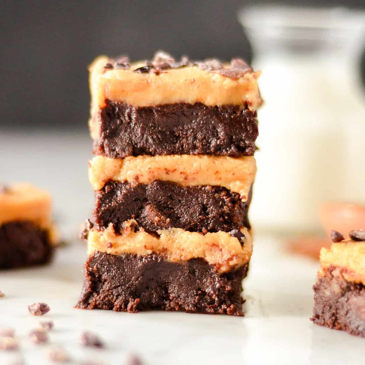 a stack of 3 Flourless Peanut Butter Brownies with peanut butter frosting