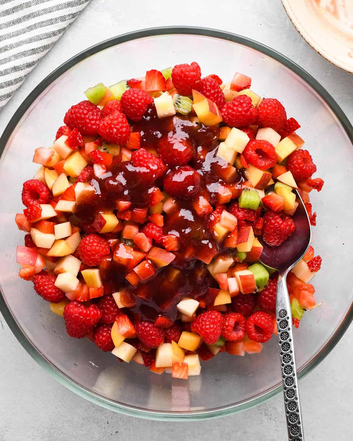 making Fruit Salsa Recipe - adding jam to fruit in a bowl