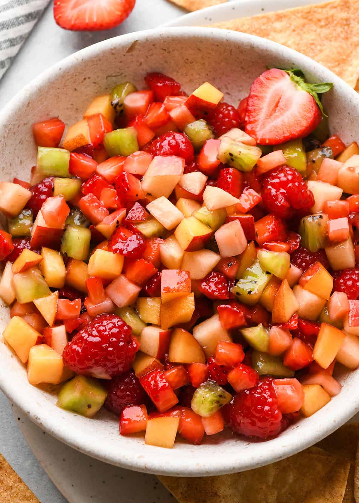a bowl of Fruit Salsa with Cinnamon Chips around it