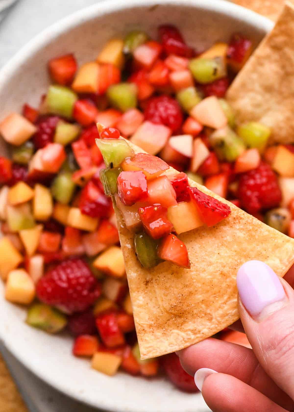 up close photo of a cinnamon chip with fruit salsa on it