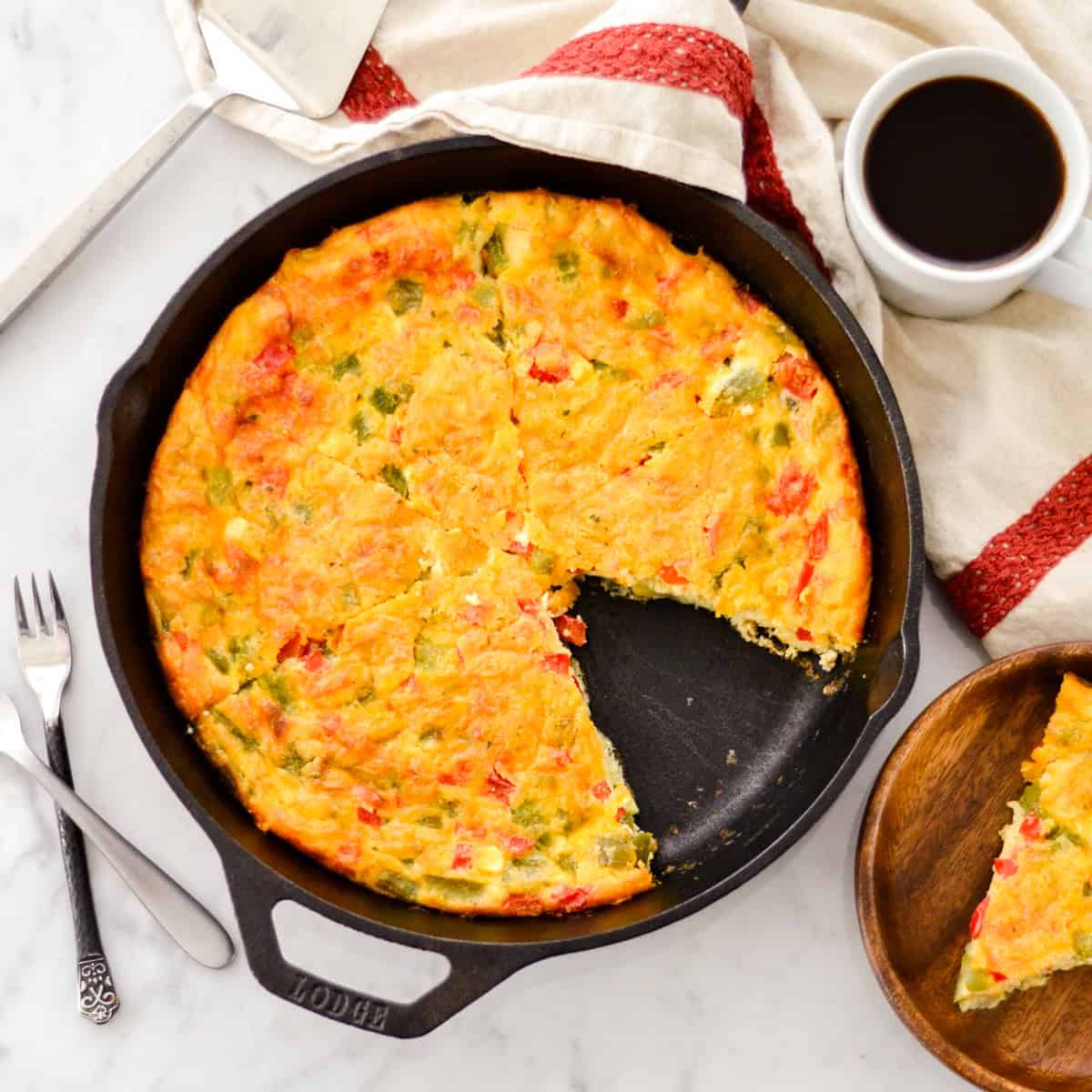 Crustless Gluten Free Quiche cut into 6 pieces in a cast iron skillet with one on a plate