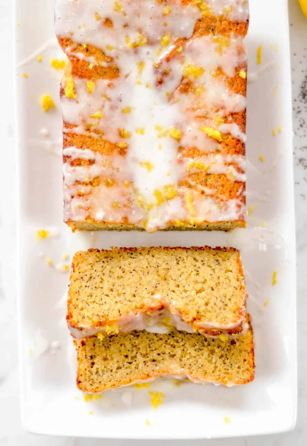 a loaf of Gluten Free Lemon Poppy Seed Bread with two slices cut out of it