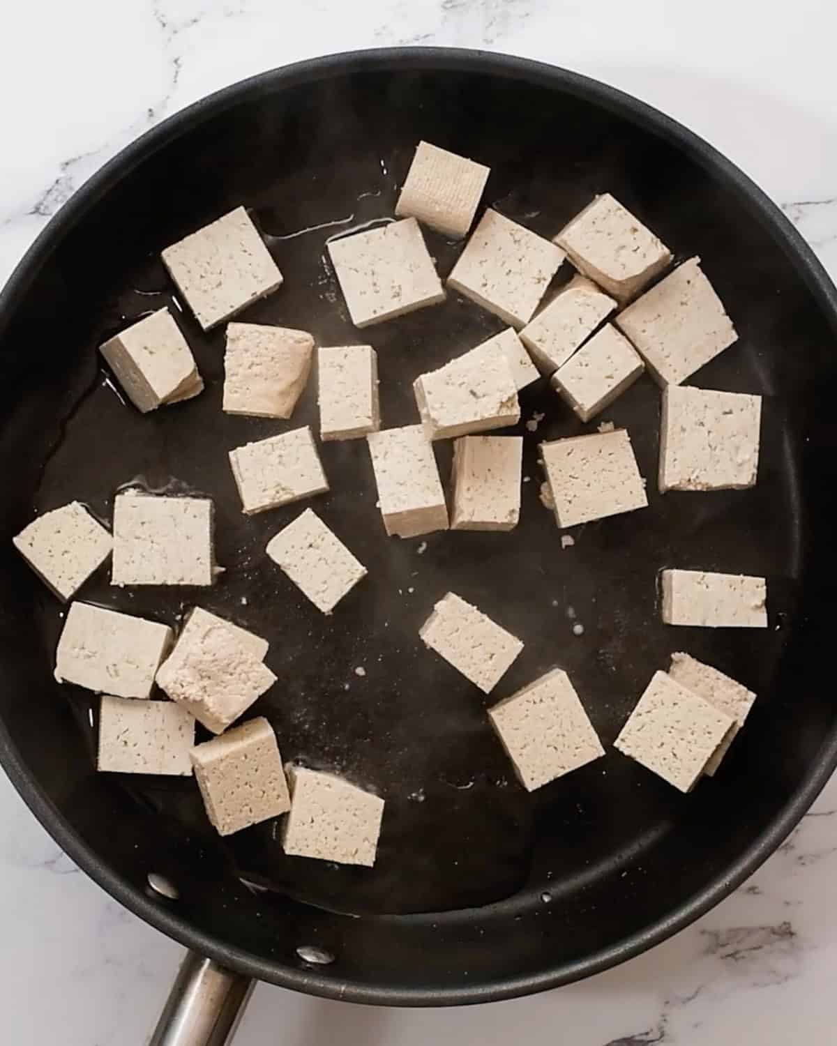 making Hoisin Tofu - cooking tofu in oil in a fry pan