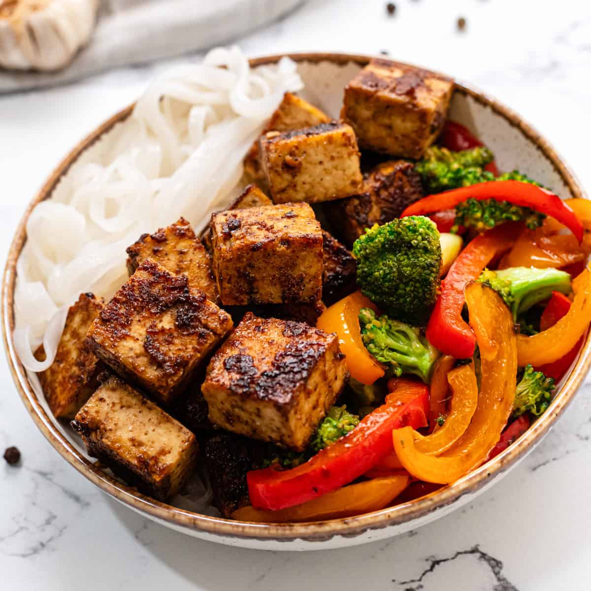 tofu with hoisin sauce in a bowl with noodles and stir fry vegetables