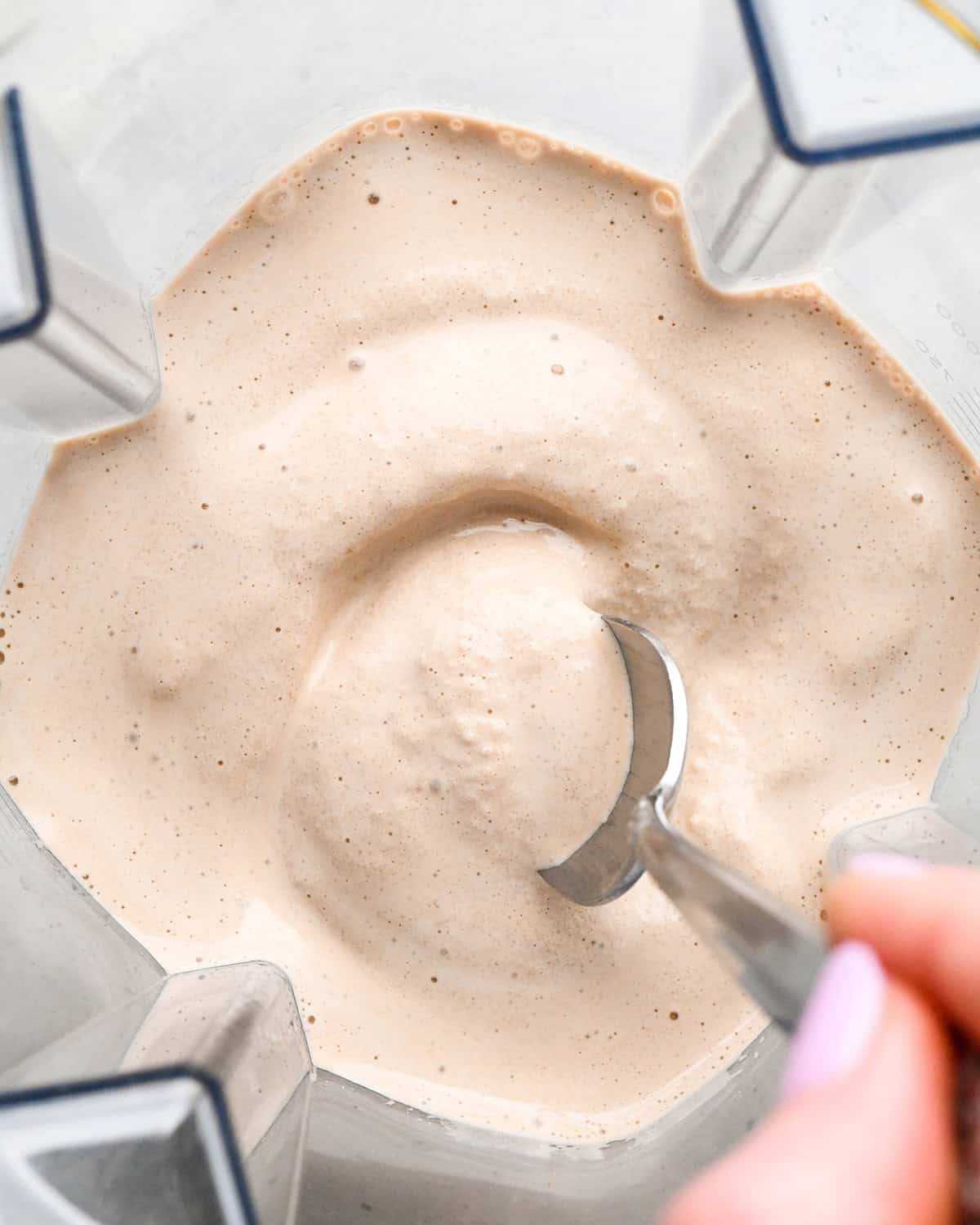 Coffee Smoothie in a blending container after blending with a spoon