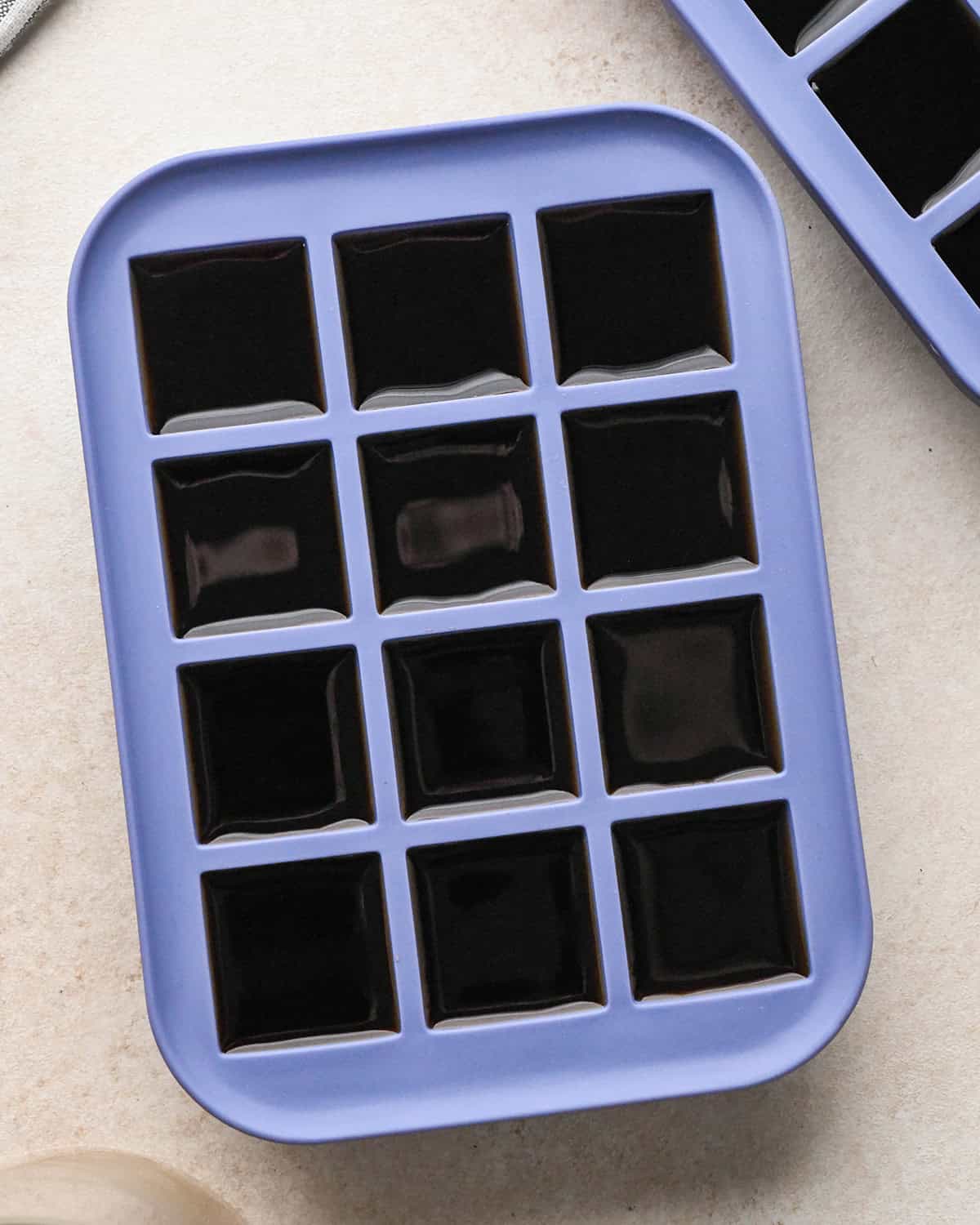 an ice cube tray filled with coffee before freezing to make Coffee Ice Cubes