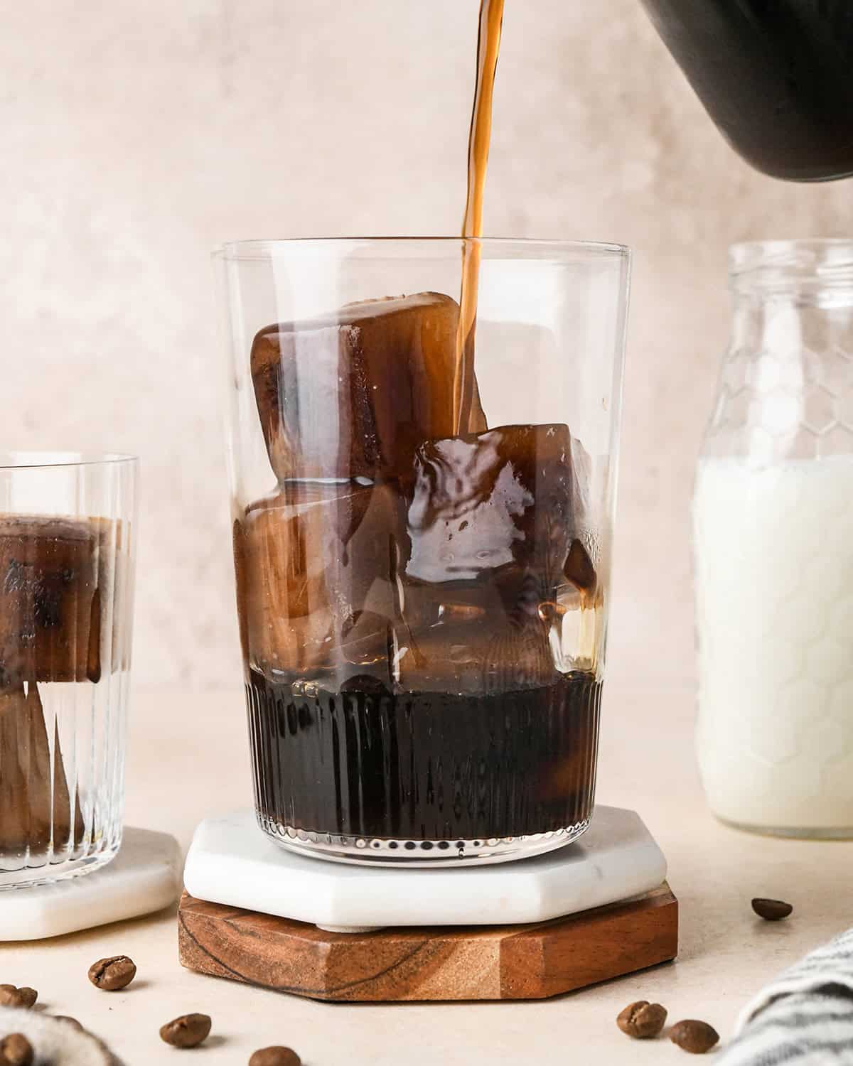 Coffee Ice Cubes in a glass with coffee being poured over them