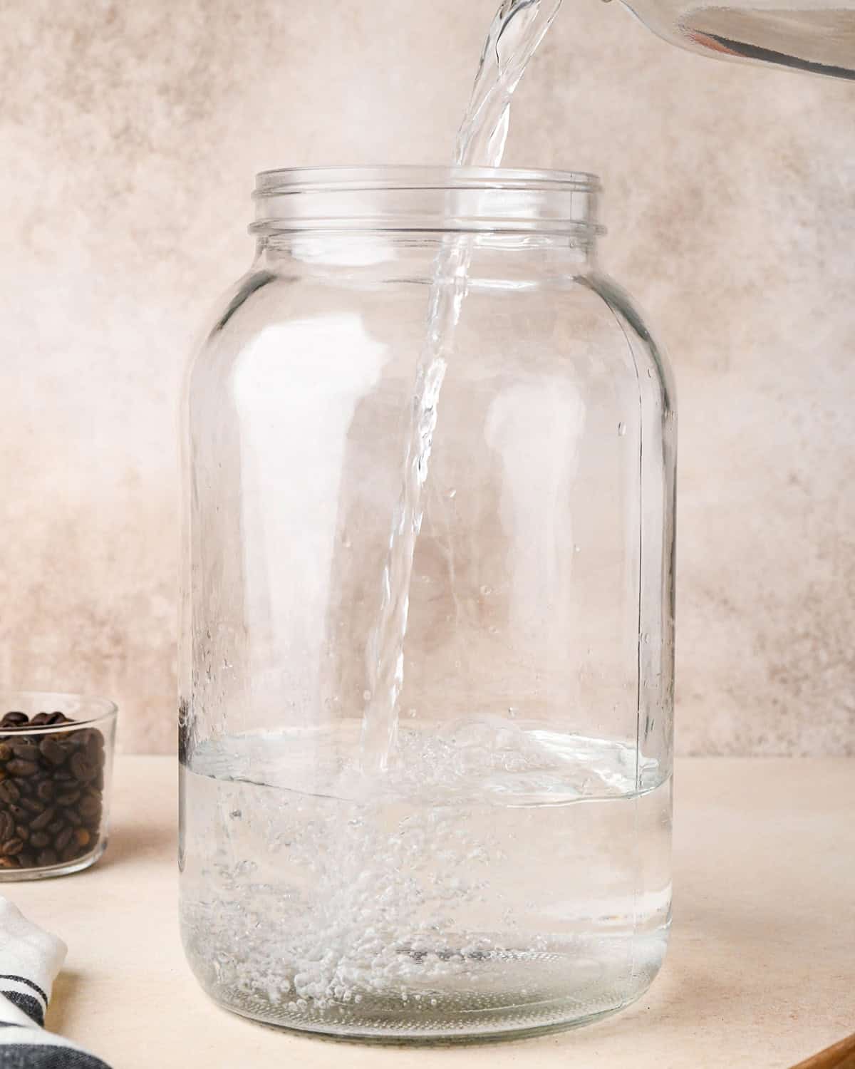 How to Make Cold Brew Coffee Recipe - water being poured into a gallon jar