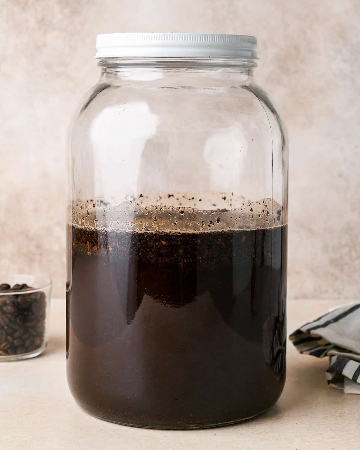 cold brew coffee steeping in a glass jar with a white lid