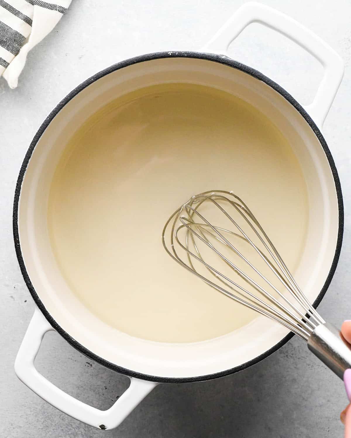 how to make simple syrup - whisking the sugar and water until dissolved in a pot