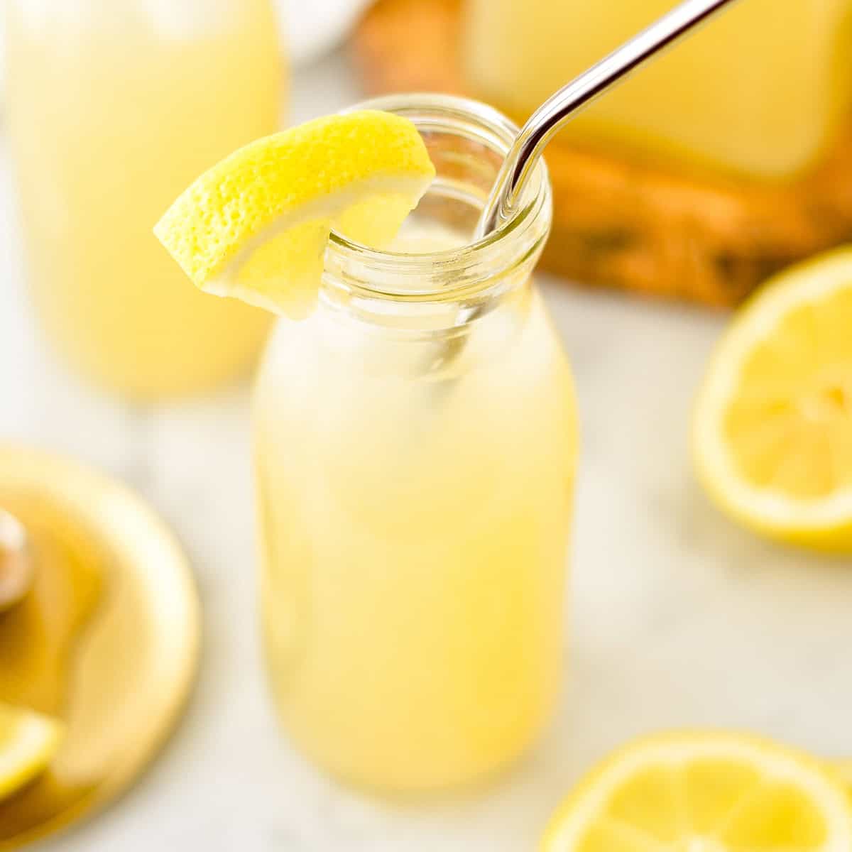 Orange Blossom Lemonade in a glass with a metal straw and a lemon wedge