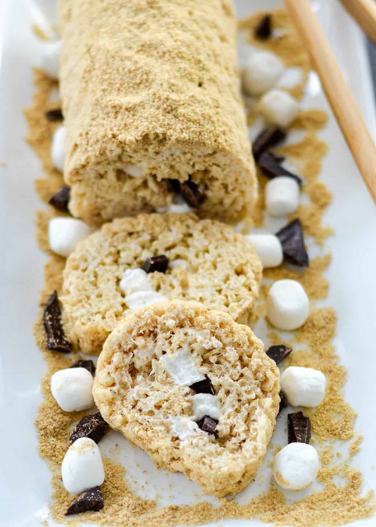 a roll of Rice Crispy Dessert Sushi with two slices cut out of it