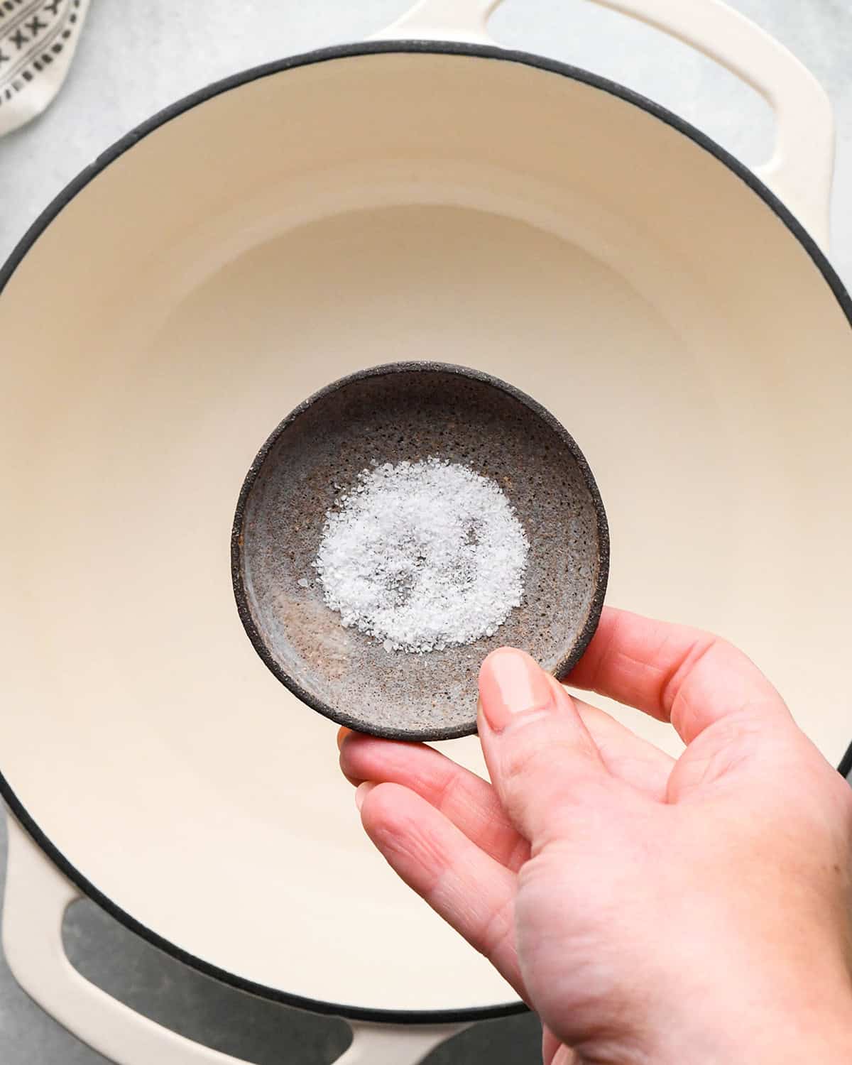 salt being held over a pot of water