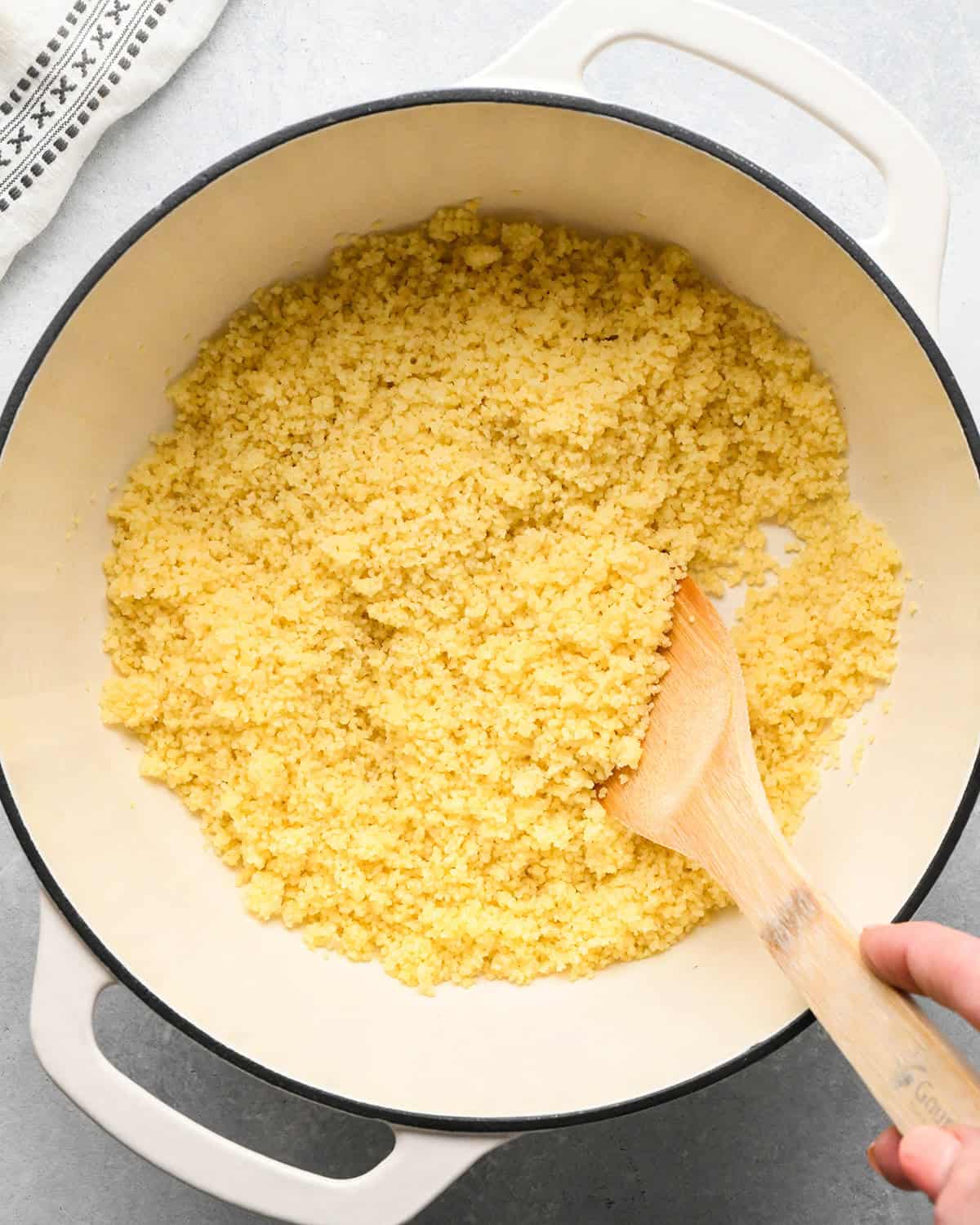 cooked couscous in a pot with a wooden spoon