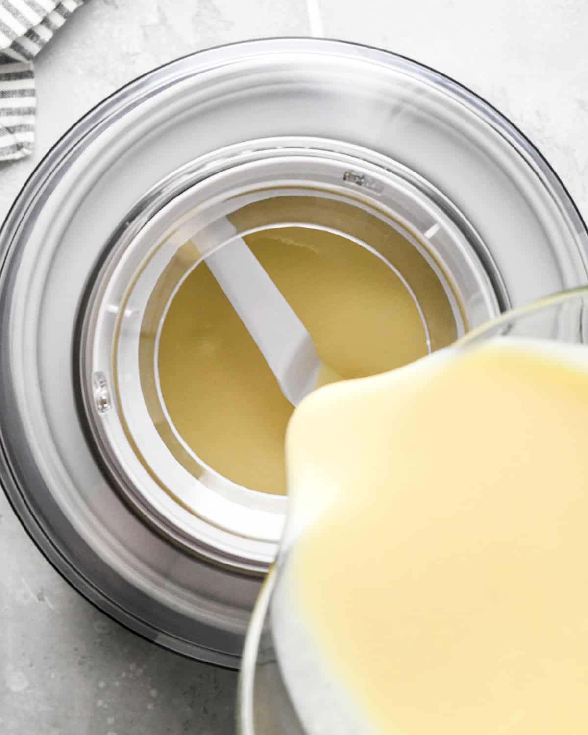 pouring Mint Chocolate Chip Ice Cream base into an ice cream maker