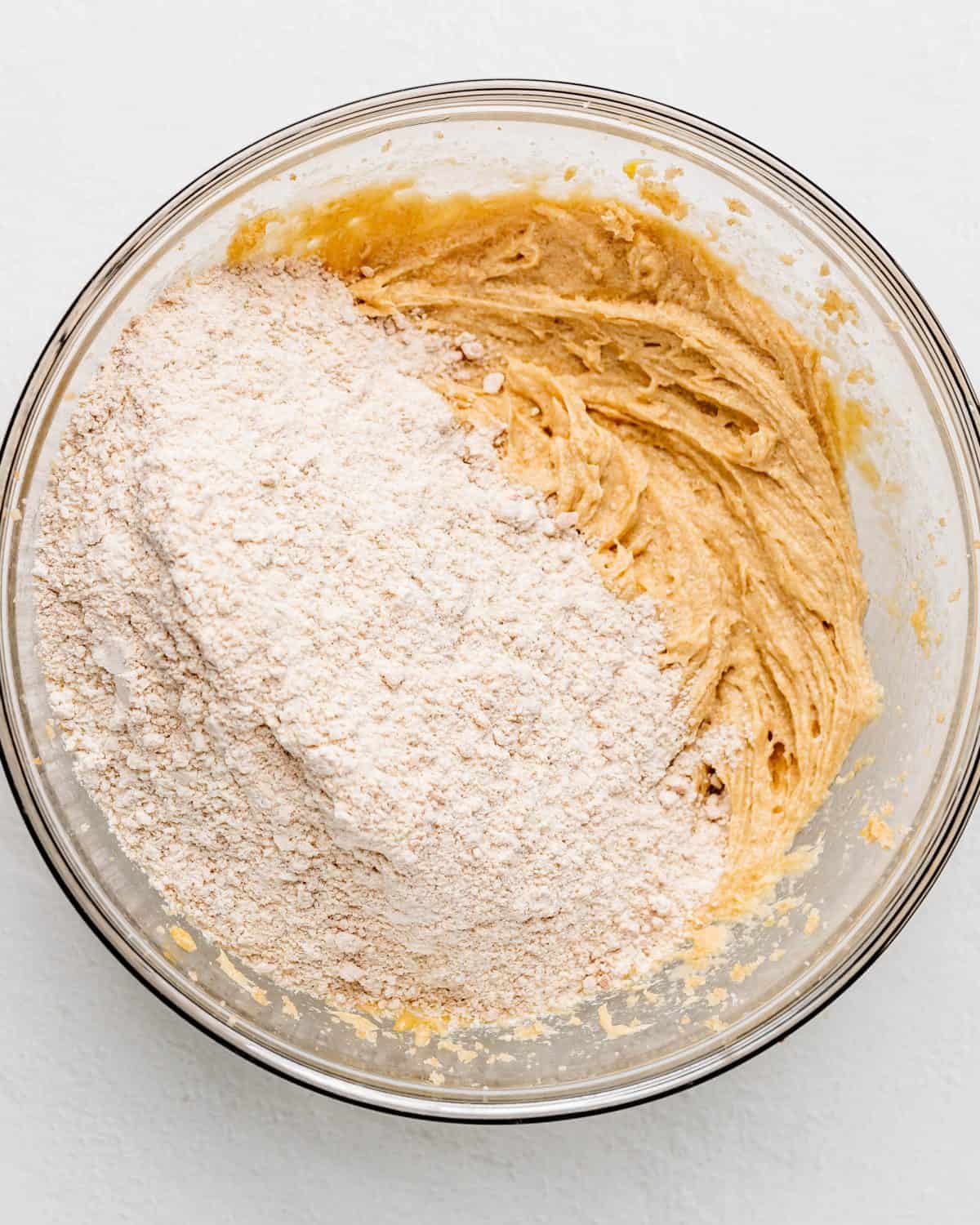 making s'mores cookies recipe - dry ingredient mixture added to the wet ingredients in a glass bowl before mixing