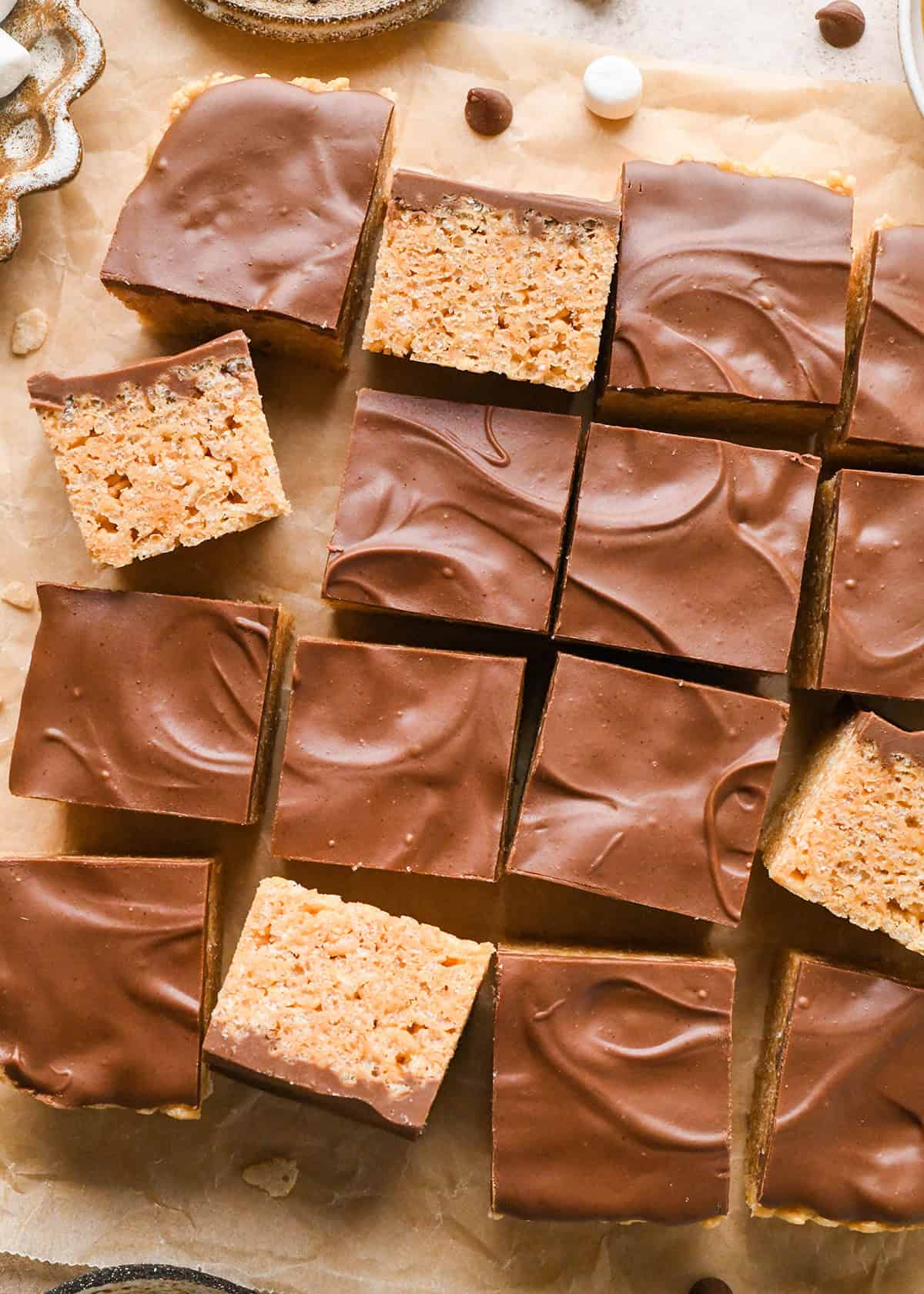 16 Peanut Butter Rice Crispy Treats cut into squares, some on their side so the inside is showing