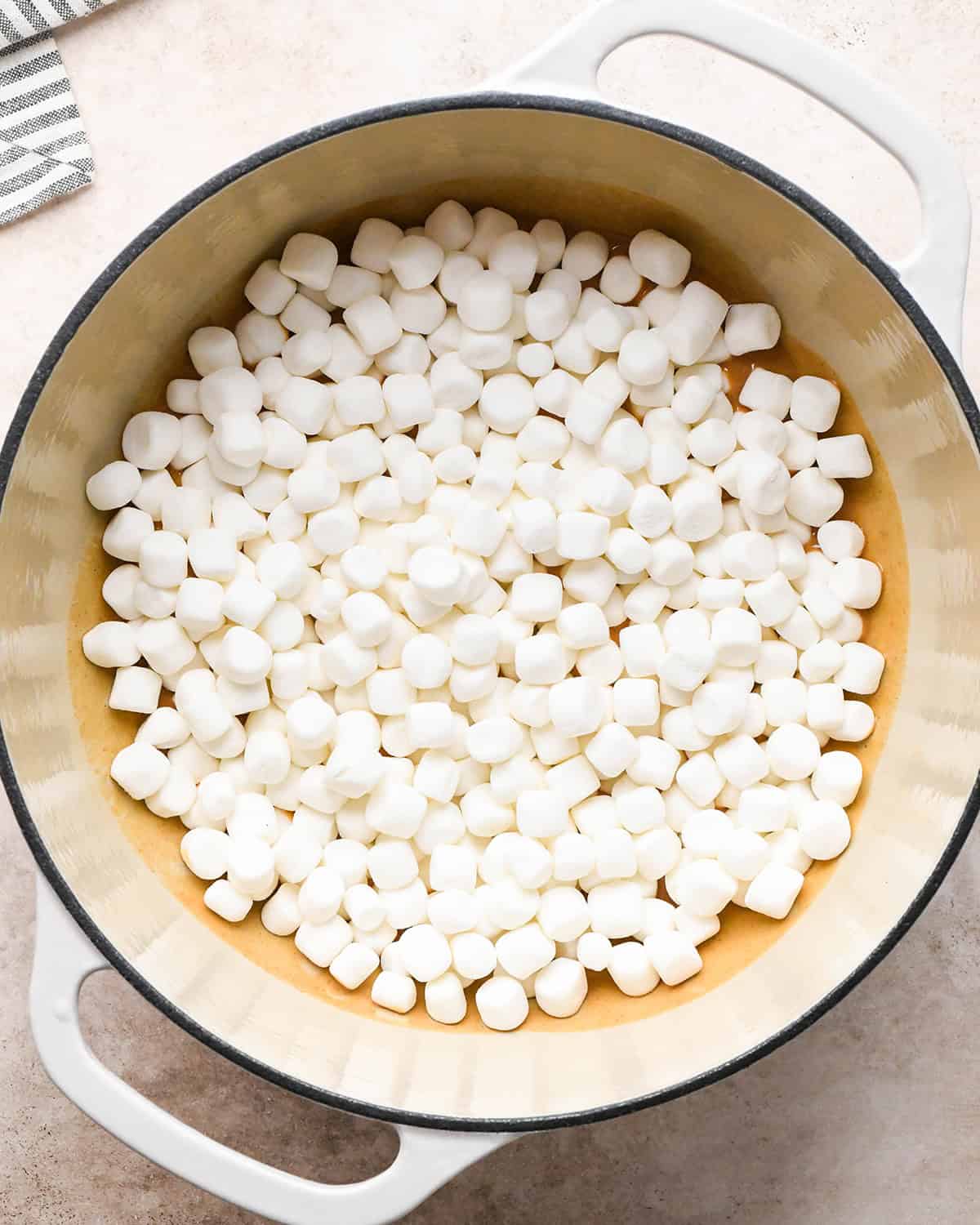 making Peanut Butter Rice Crispy Treats - marshmallows added to the peanut butter mixture before stirring