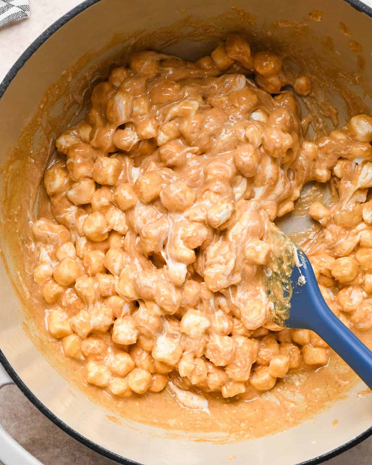 making Peanut Butter Rice Crispy Treats - melting peanut butter and marshmallows in a pwn with a spatula