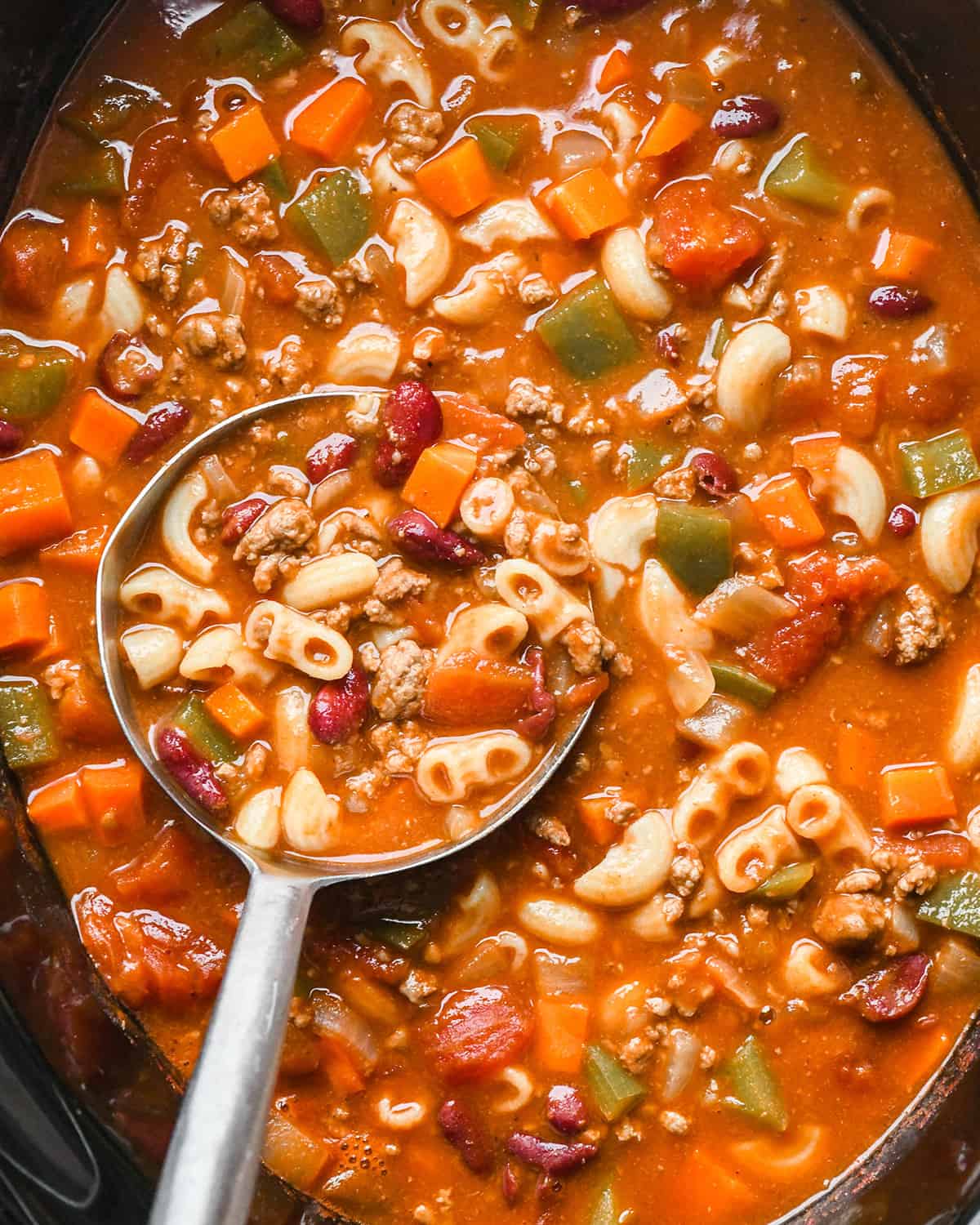 a ladle taking a scoop of Hamburger Soup from a crock pot