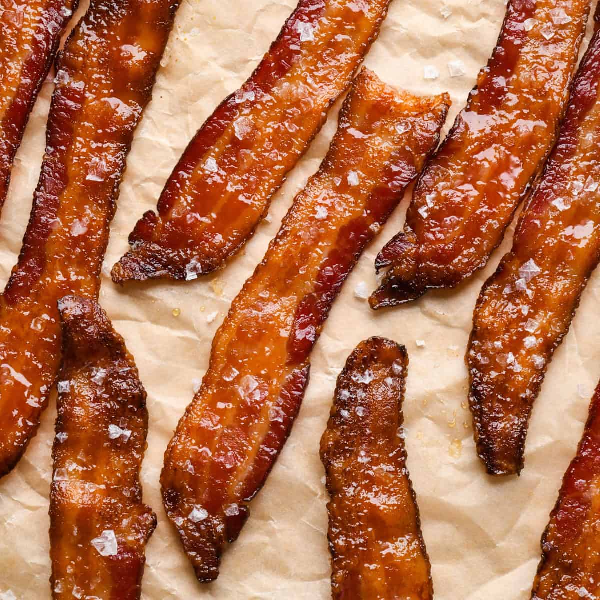 Crispy maple bacon topped with sea salt on parchment paper