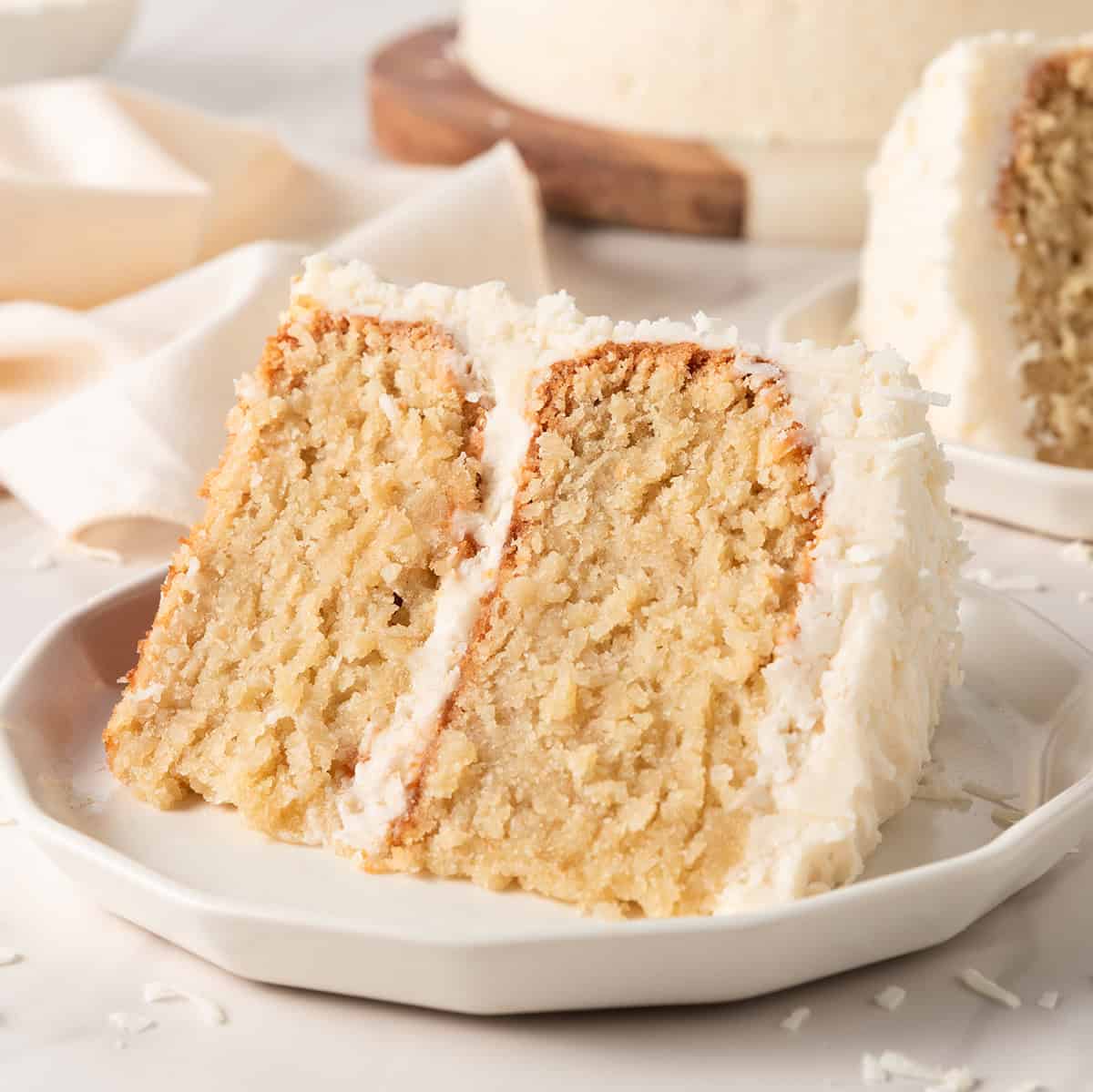 a slice of coconut cake with coconut frosting on a plate