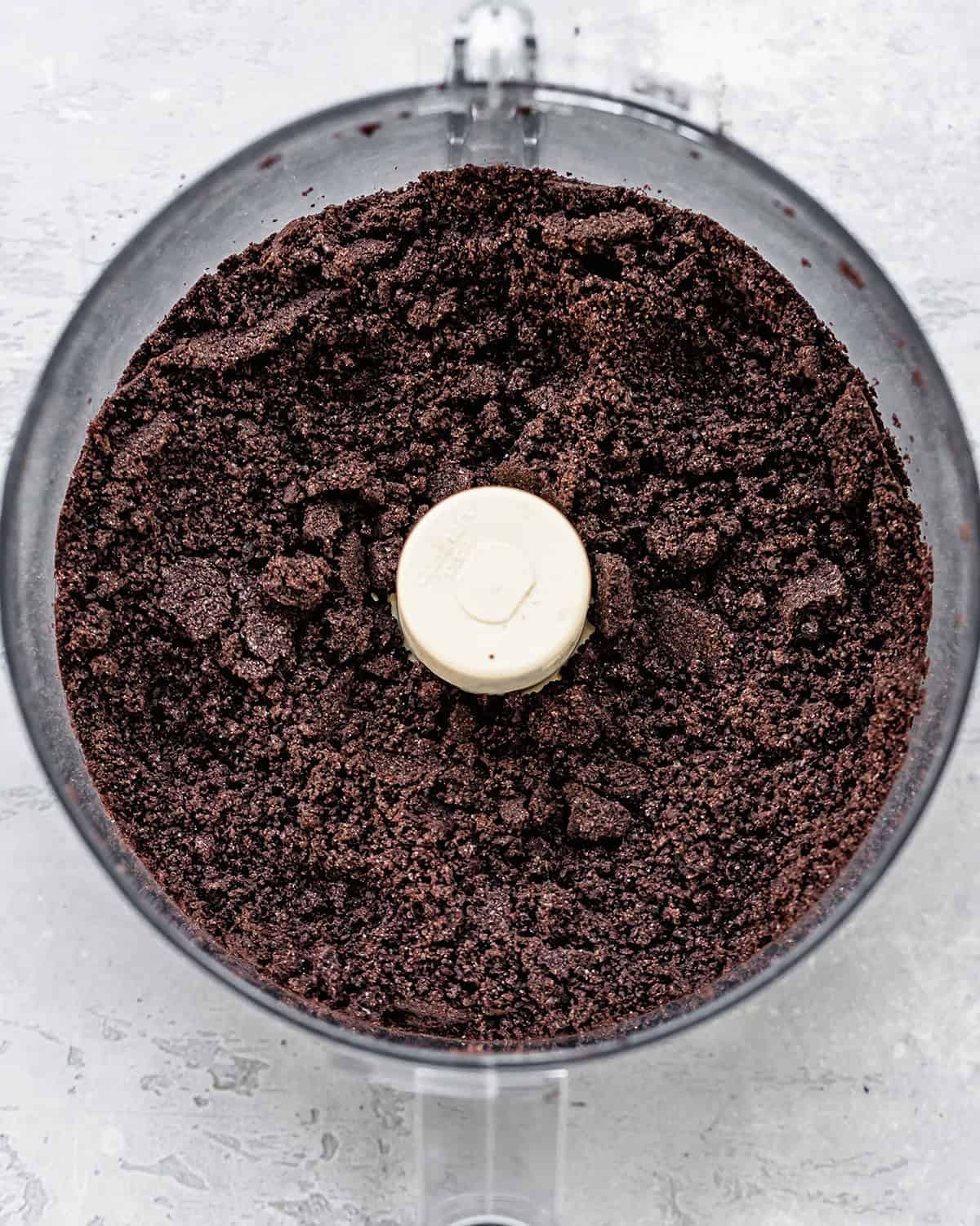 Oreo cookie crumbs in a food processor after processing