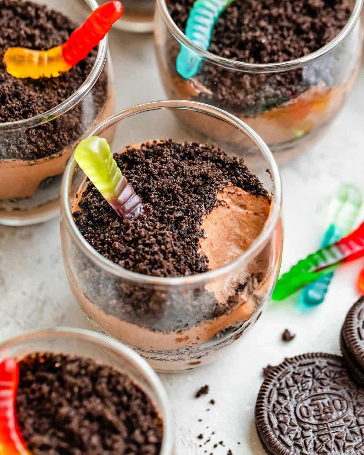 4 Dirt Cups, one with a bite taken out of it so the chocolate pudding is visible