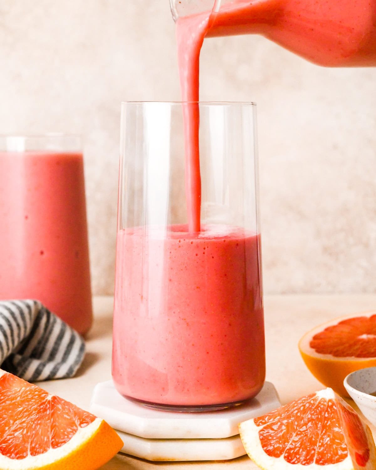 making a grapefruit smoothie: overview photo of blended smoothie being poured into a clear glass.