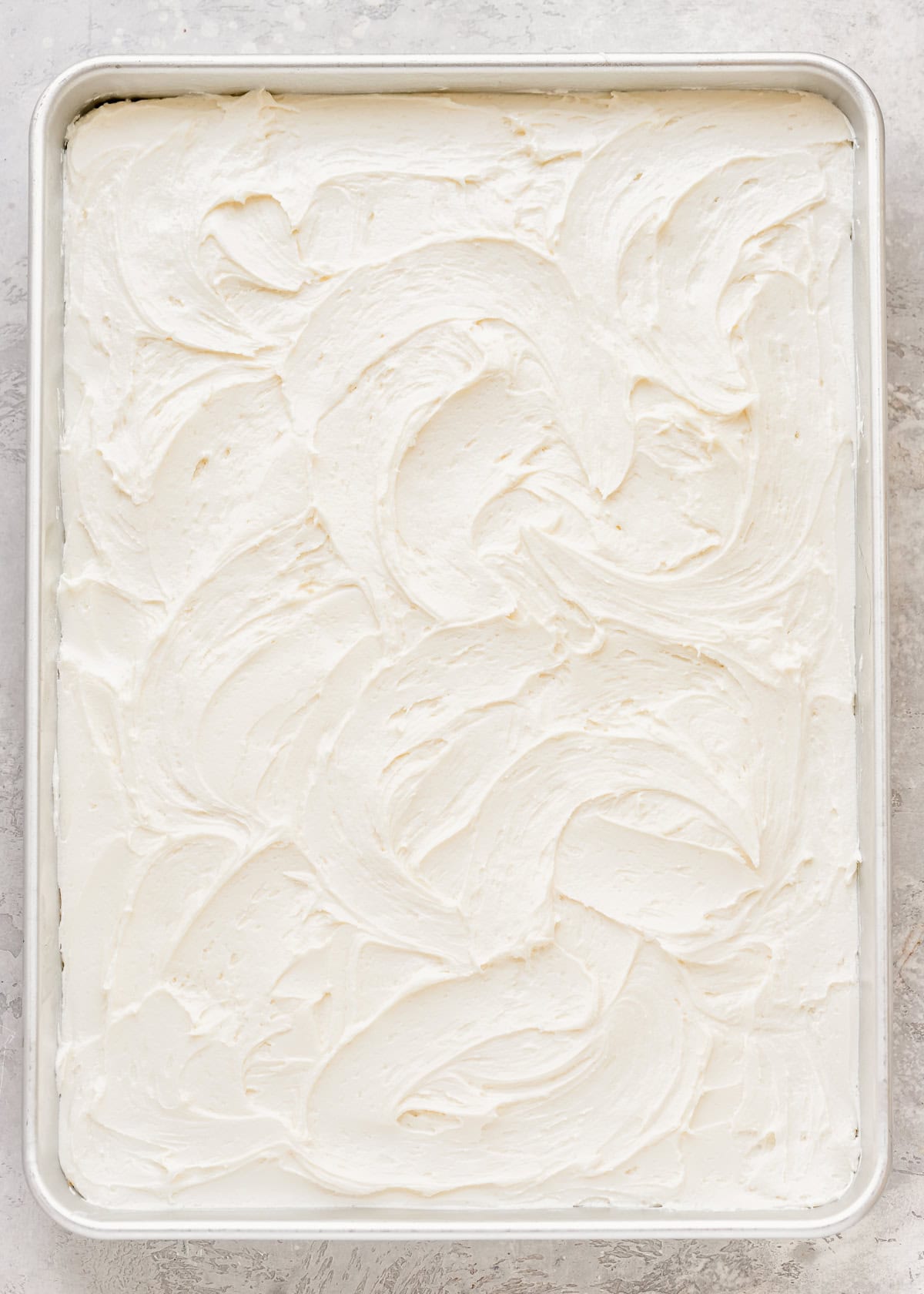 Vanilla Sheet Cake spread with vanilla frosting