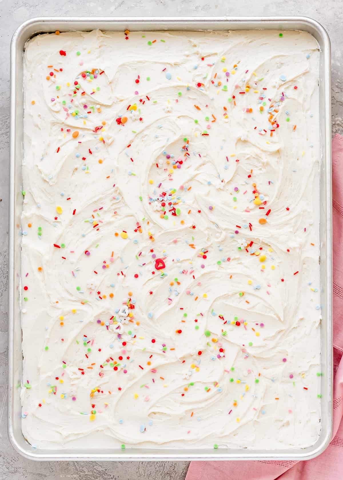 overhead view of Vanilla Sheet Cake with white frosting and sprinkles