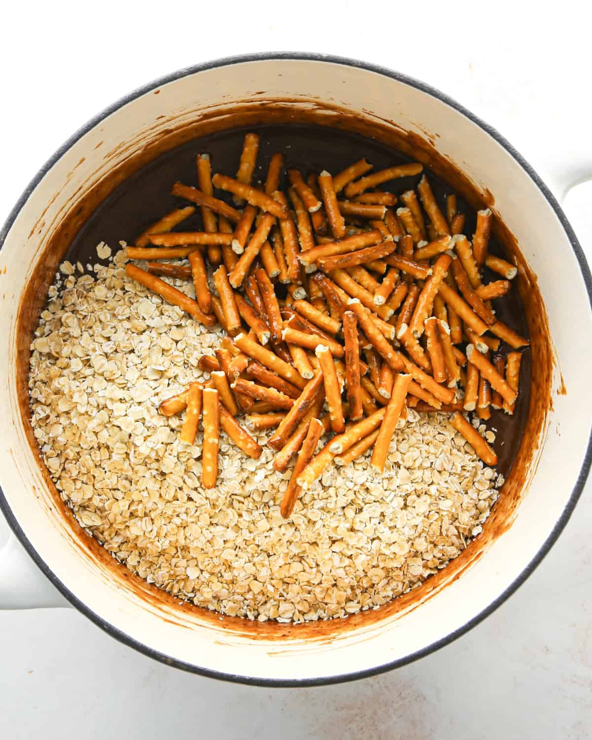 Making bird's nest cookies: overhead photo of quick-cooking oatmeal, pretzels, and other ingredients added to a large cooking pot.