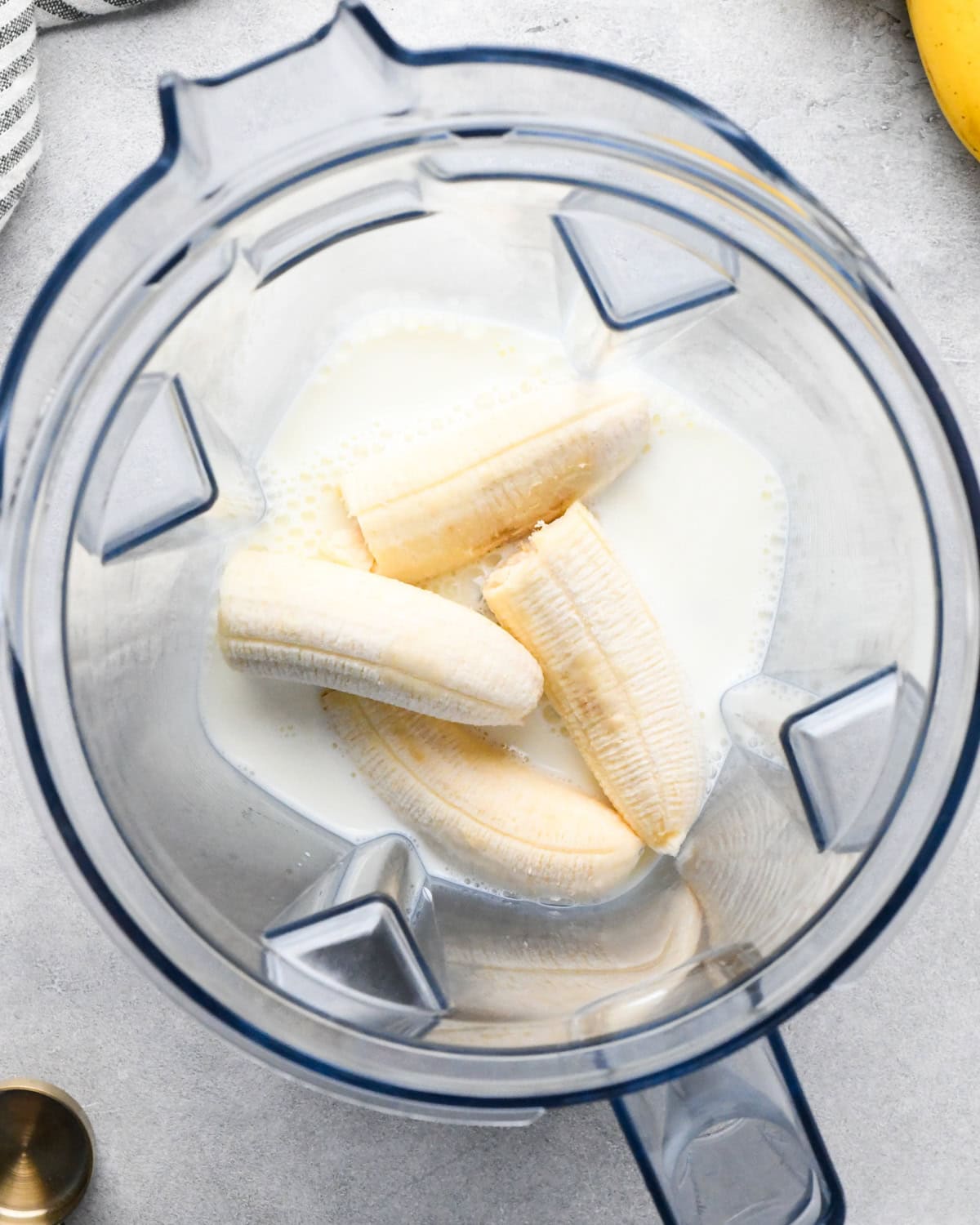 making chocolate banana smoothie: overhead photo of bananas and milk in a blender.