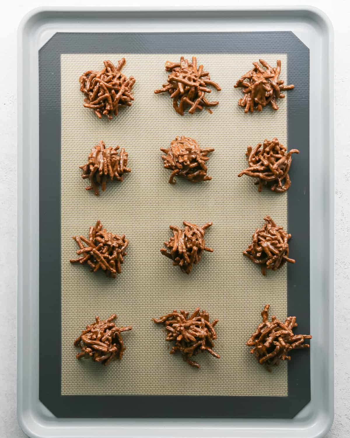 Making Haystack Cookies: overhead photo of a baking sheet topped with 12 scooped-out semisweet chocolate haystack cookies.