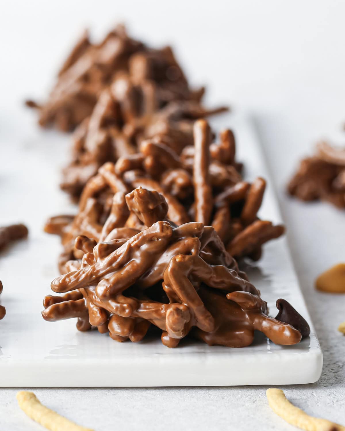 Making Haystack Cookies: close-up photo of semisweet chocolate haystack cookies sitting on a light surface.