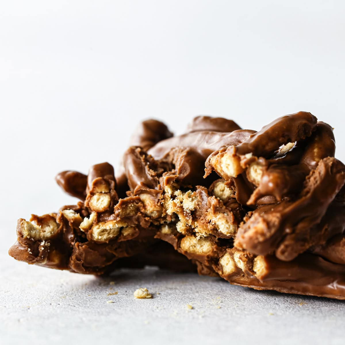 Making Haystack Cookies: close-up photo of a semisweet chocolate haystack cookie with a bite taken out and sitting on a light-colored surface.