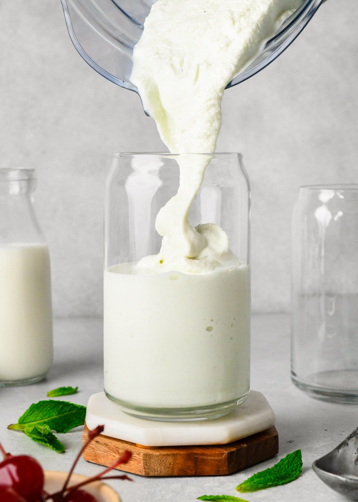 shamrock shake being poured into a glass from a blending container.