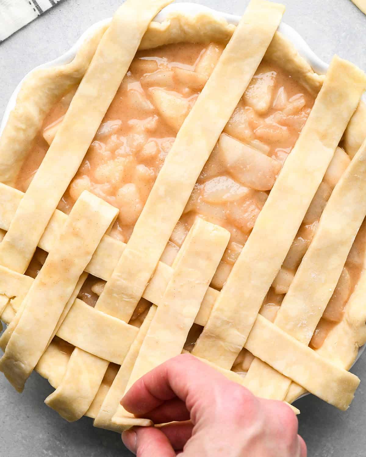 photo showing how to make a lattice pie crust - adding the third vertical strip