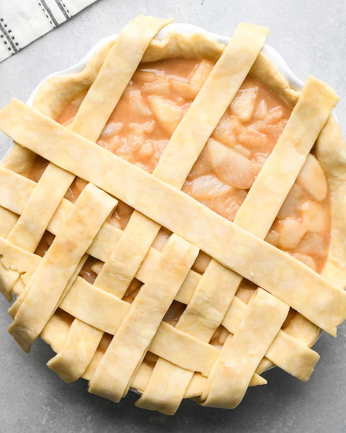photo showing how to make a lattice pie crust - adding the third vertical strip