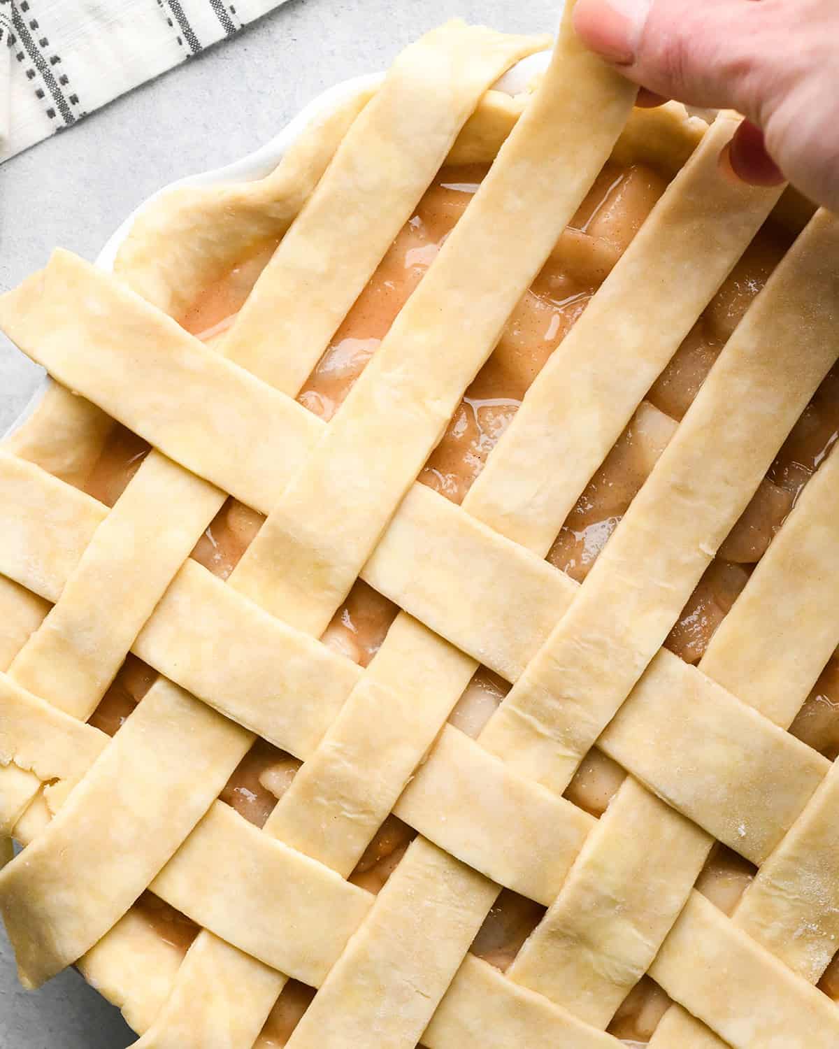 photo showing how to make a lattice pie crust - adding the third vertical strip
