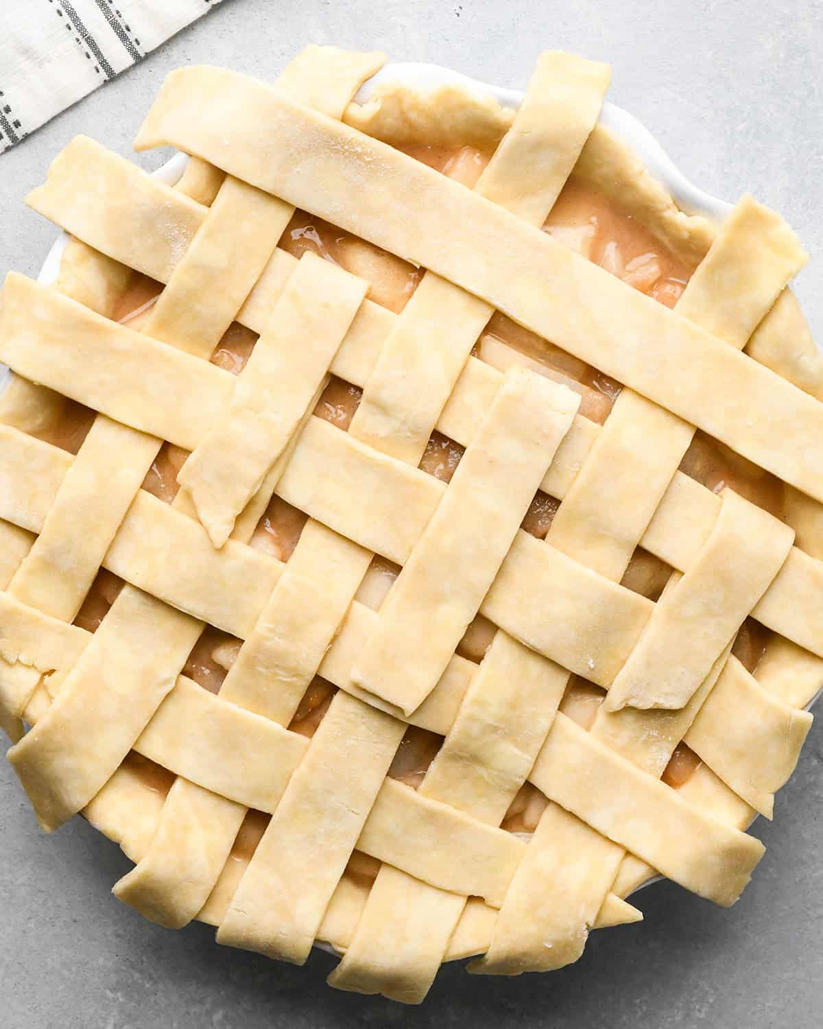 photo showing how to make a lattice pie crust - adding the fifth vertical strip