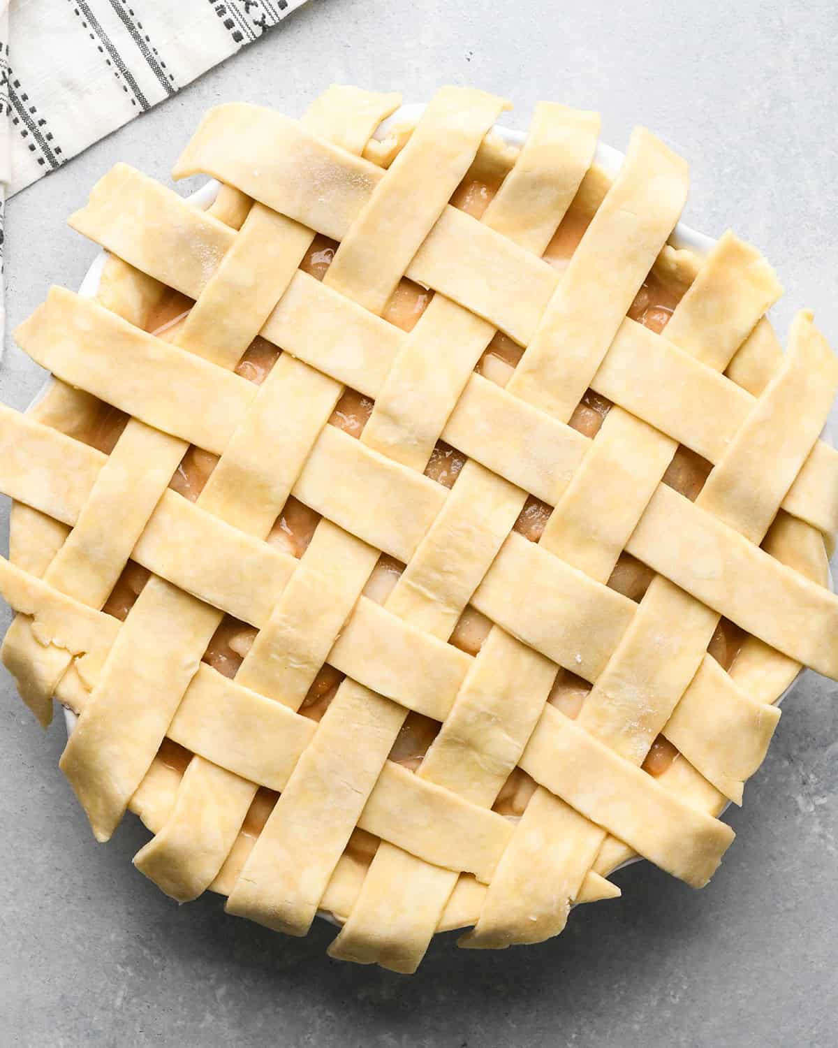 photo showing how to make a lattice pie crust - adding the fifth vertical strip