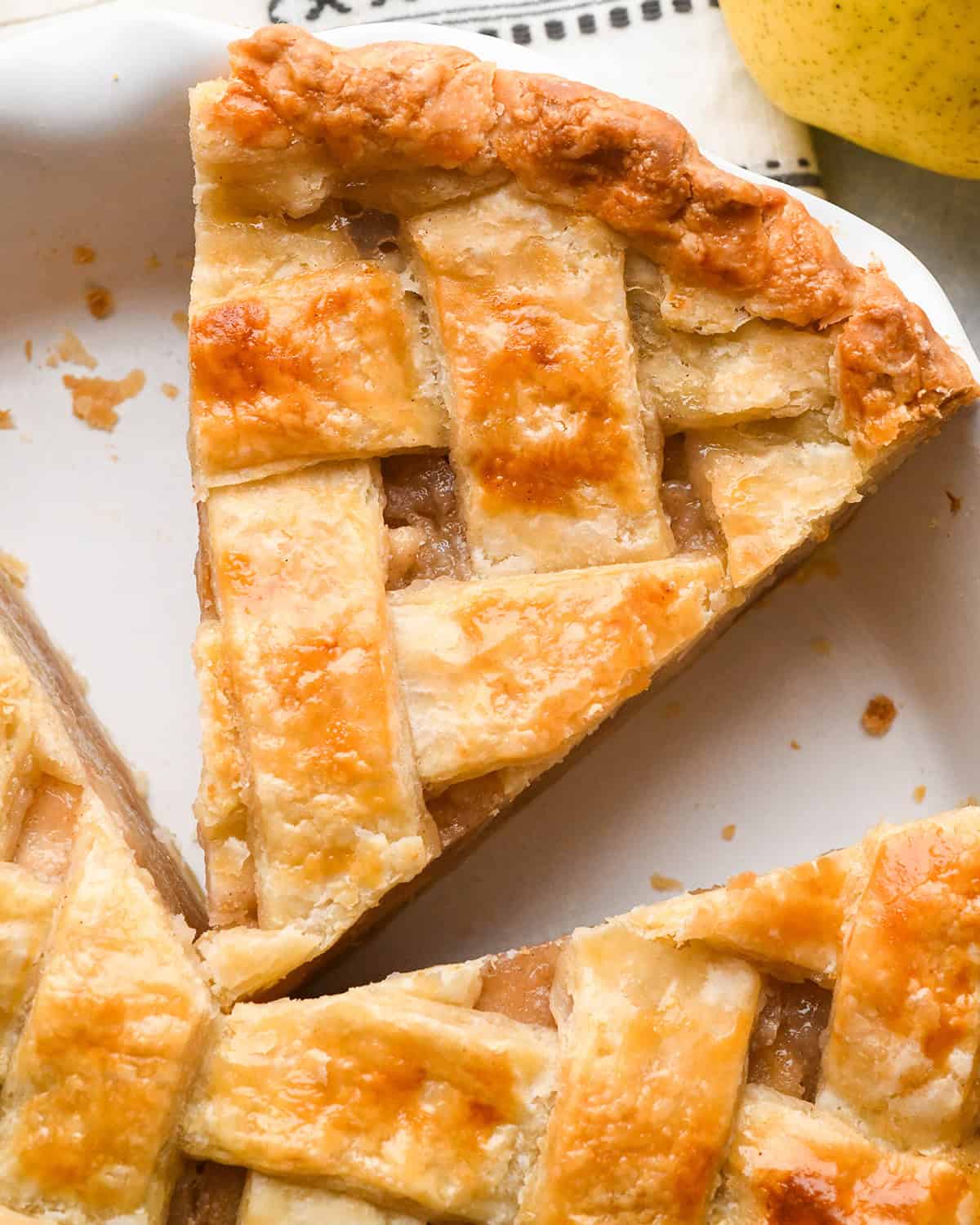 close up photo of a slice of pie with a Lattice Pie Crust in a white pie dish