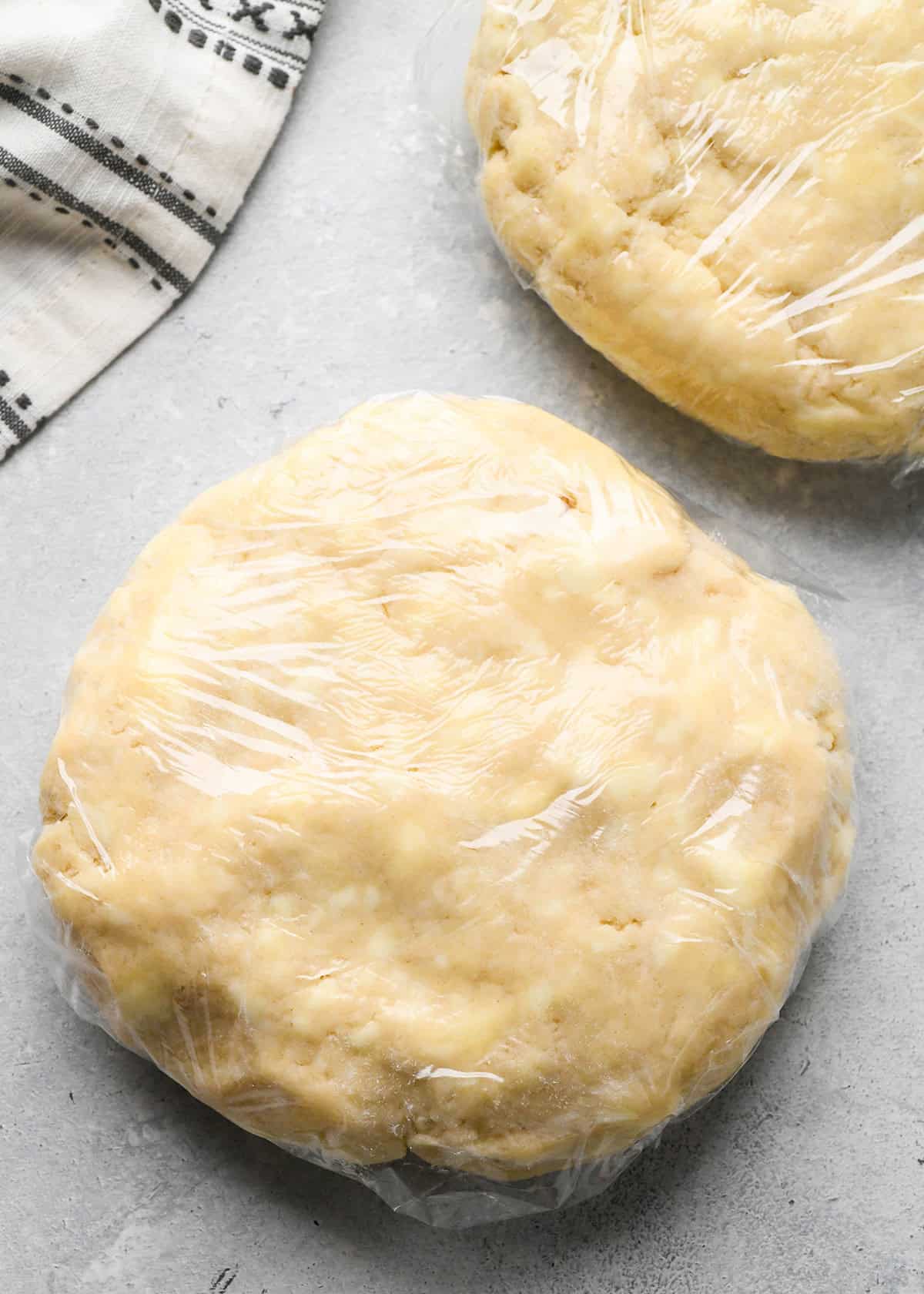 making homemade pie crust - two discs wrapped in plastic wrap to chill
